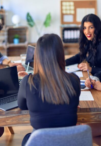 Group of business workers smiling happy and confident. Working together with smile on face  using laptop and speaking at the office
